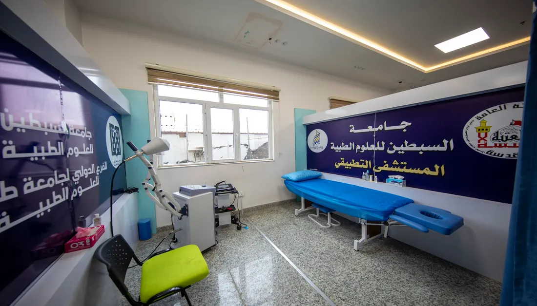 غرفة علاج طبيعي مجهزة بسرير وأجهزة علاجية في مركز التأهيل الطبي